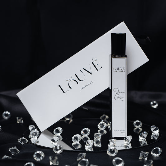 LOUVÉ Divine Cherry Parfumöl – eleganter Duftflakon mit weißer LOUVÉ Box und funkelnden Kristallen auf schwarzem Hintergrund