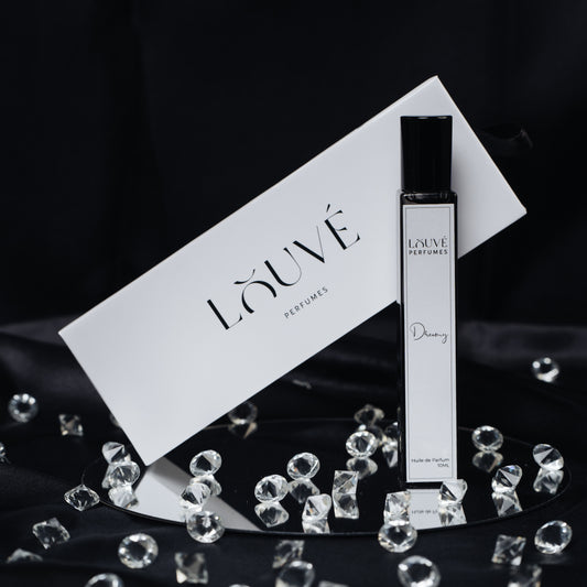 LOUVÉ Dreamy Huile Parfumée – eleganter Roll-on Duftflakon mit LOUVÉ Box und Kristall-Dekor auf schwarzem Hintergrund