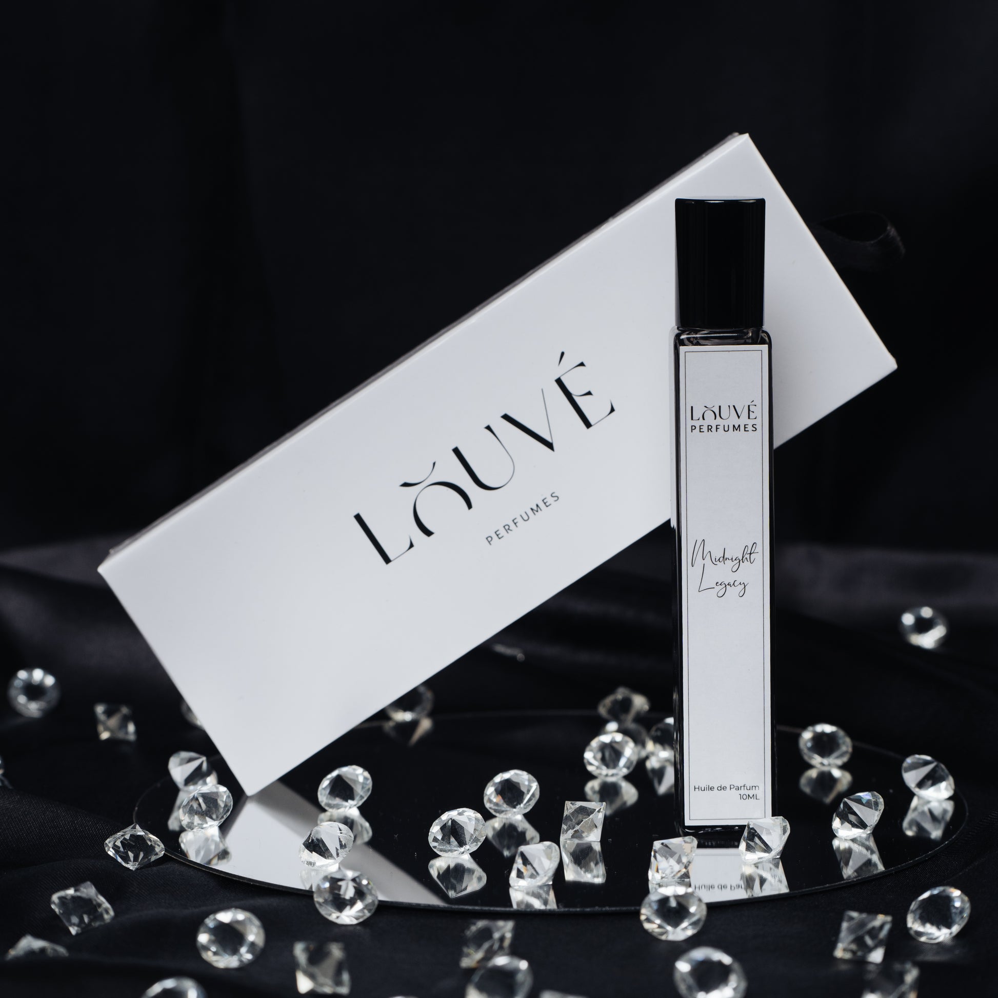 „LOUVÉ Midnight Legacy Huile Parfumée – eleganter Roll-on Duftflakon mit LOUVÉ Box und Kristall-Dekor auf schwarzem Hintergrund