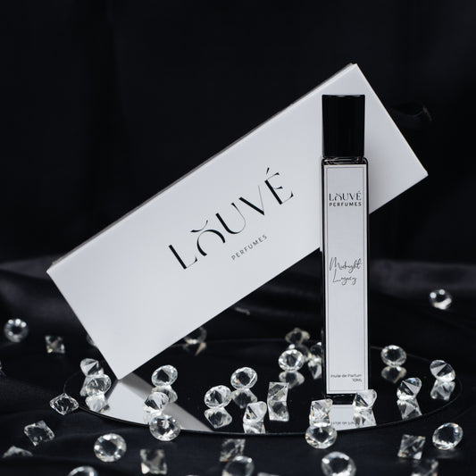 „LOUVÉ Midnight Legacy Huile Parfumée – eleganter Roll-on Duftflakon mit LOUVÉ Box und Kristall-Dekor auf schwarzem Hintergrund